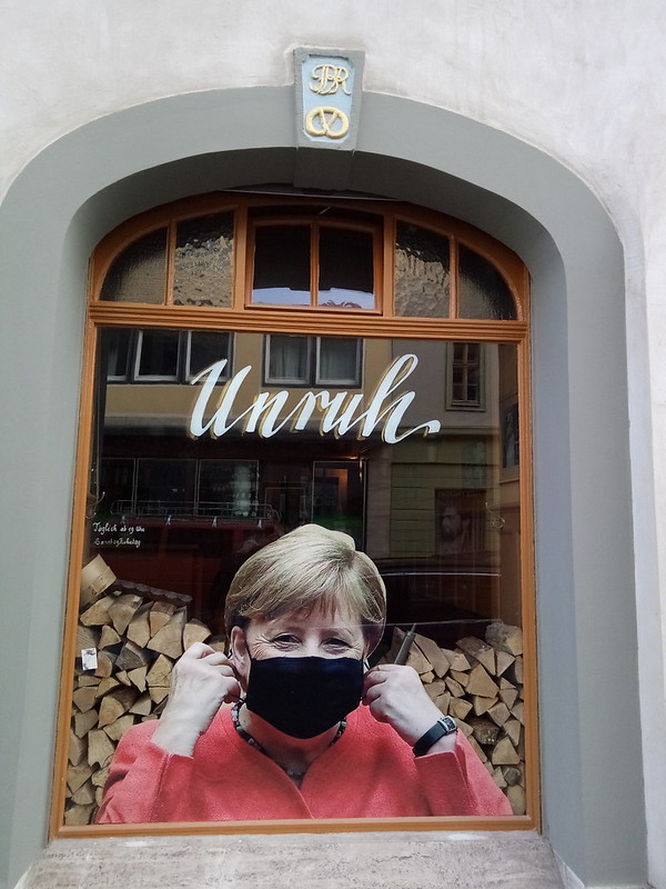 Fenster des "Unruh" in Weimar mit Foto der Kanzlerin Merkel mit Mundschutzmaske