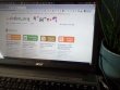 Labdoo.org website on an old laptop next to a plant in a flower pot