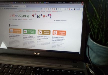 Labdoo.org website on an old laptop next to a plant in a flower pot