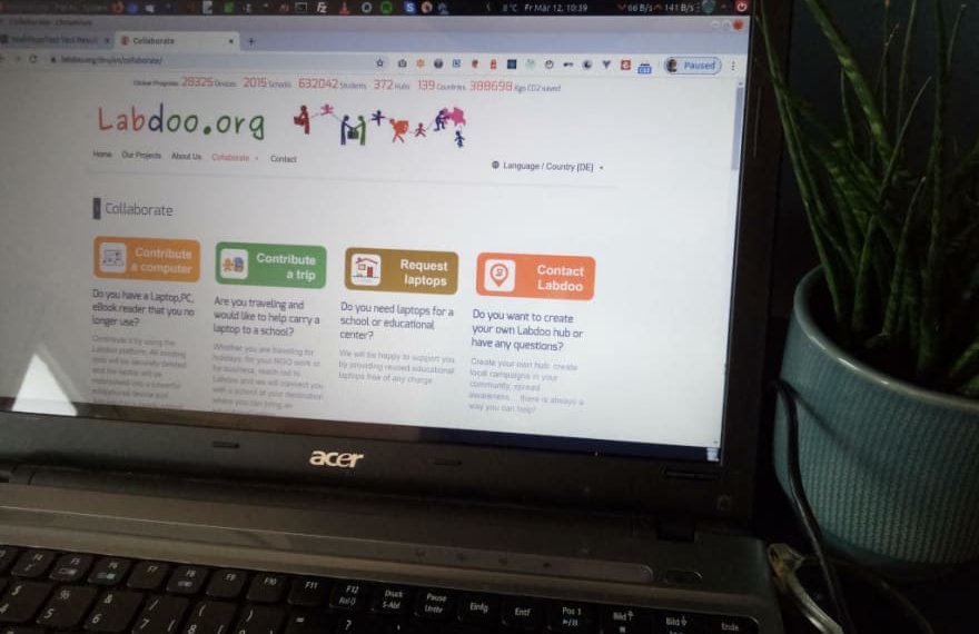 Labdoo.org website on an old laptop next to a plant in a flower pot