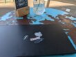 Schwarzes Laptop mit minimalistischen Aufklebern auf einem verranzten blauen Caféhaustisch in Düsseldorf