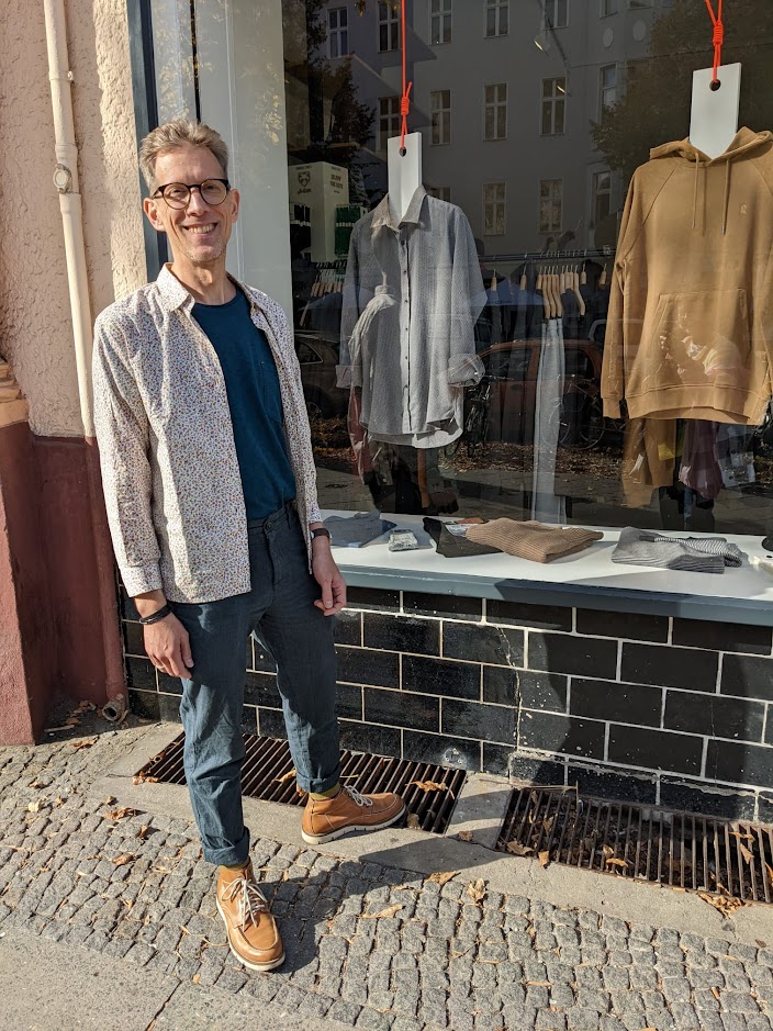 Mann vor Schaufenster mit ökologischer Männermode (Loveco Store in Berlin-Kreuzberg)