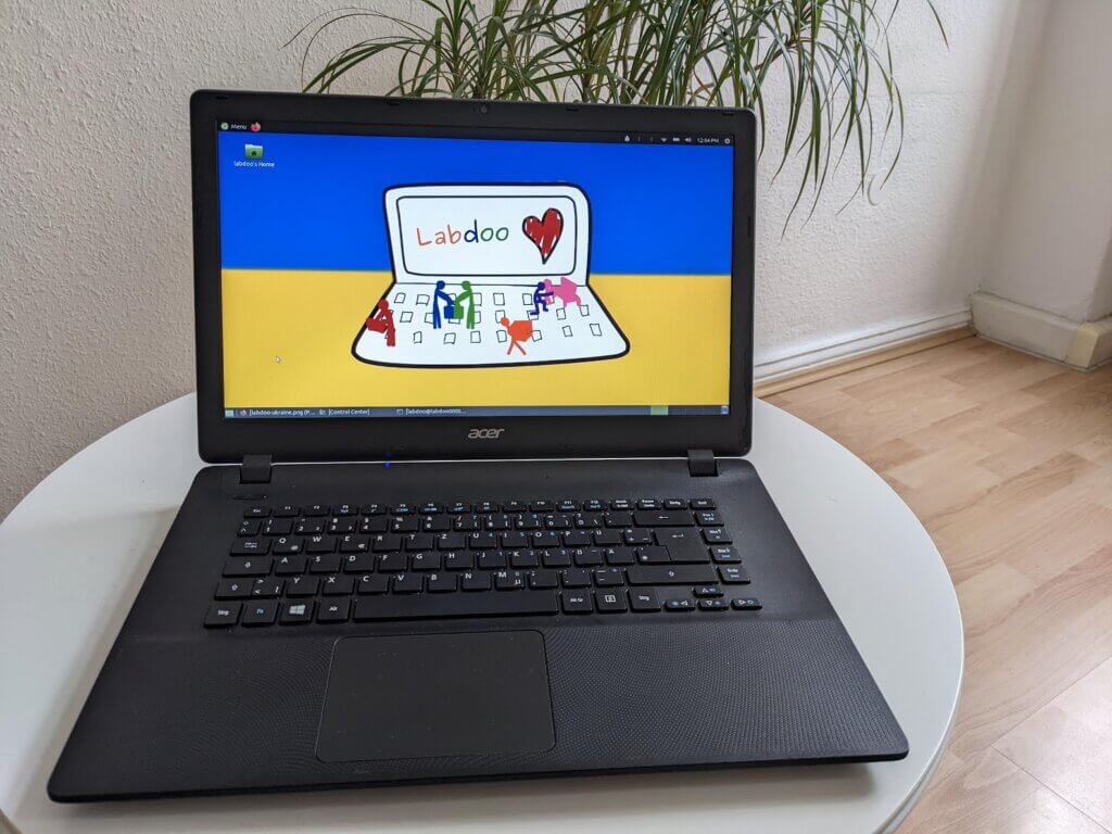 laptop showing a screen with labdoo artwork in front of the colors of the Ukrainian flag