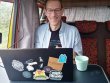 man at a laptop in a camper van