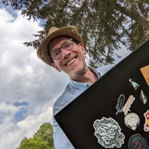 Man with a laptop and wearing a straw hat on a rural meadow
