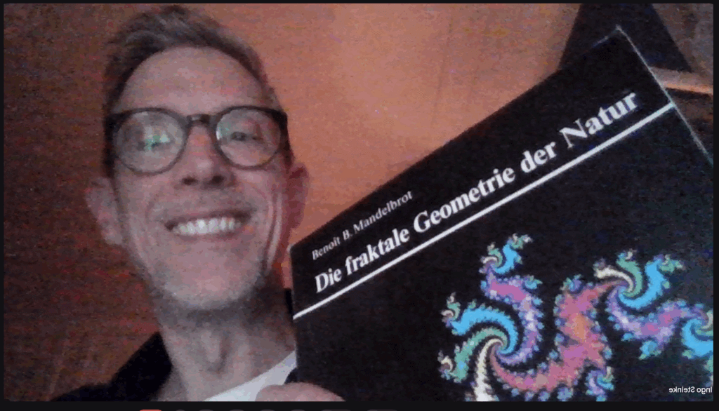 Ingo Steinke holding a classic textbook about fractals