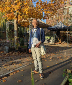 Ingo Steinke in front of the venue under sunny autumn trees